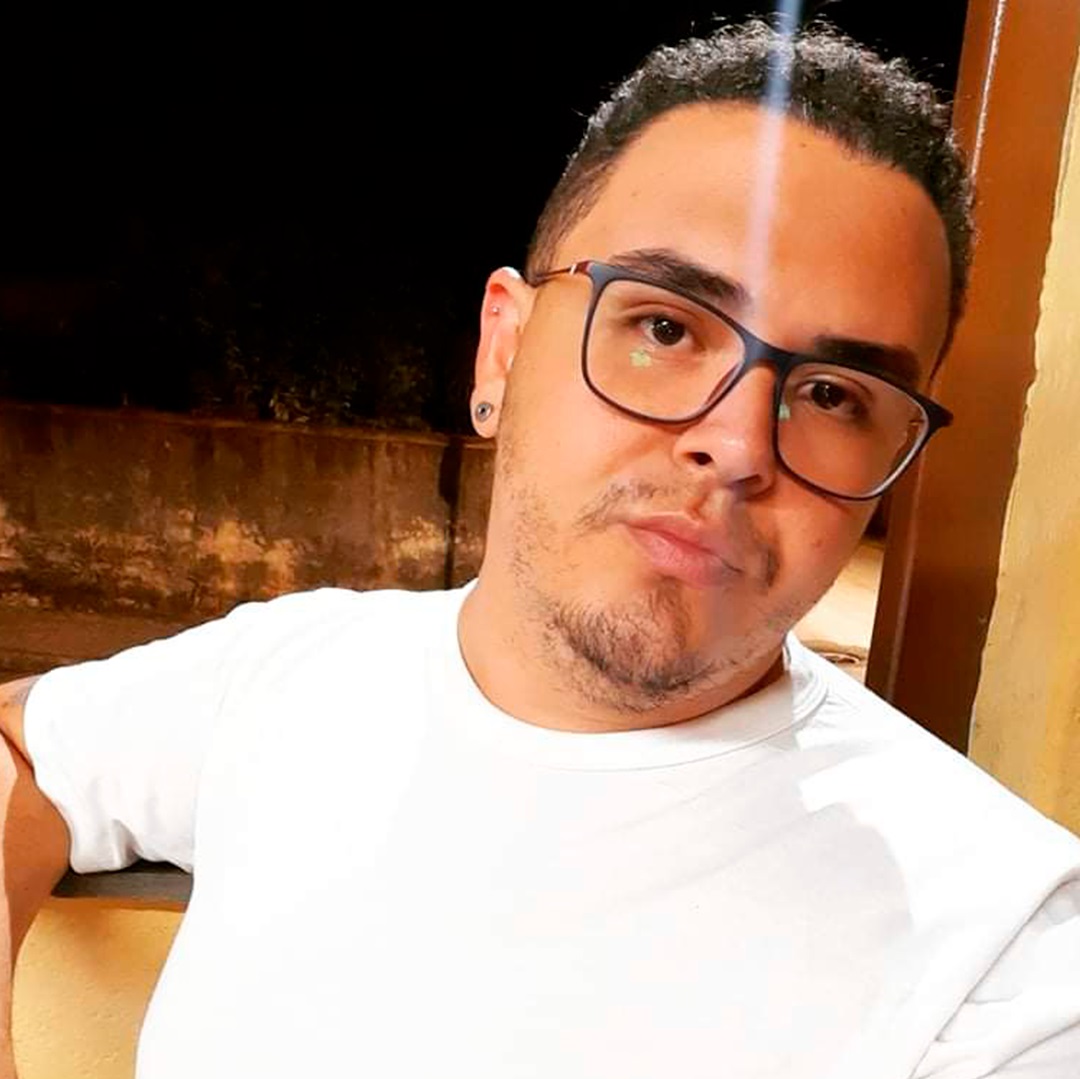 jovem homem de óculos de brinco e camisa branca