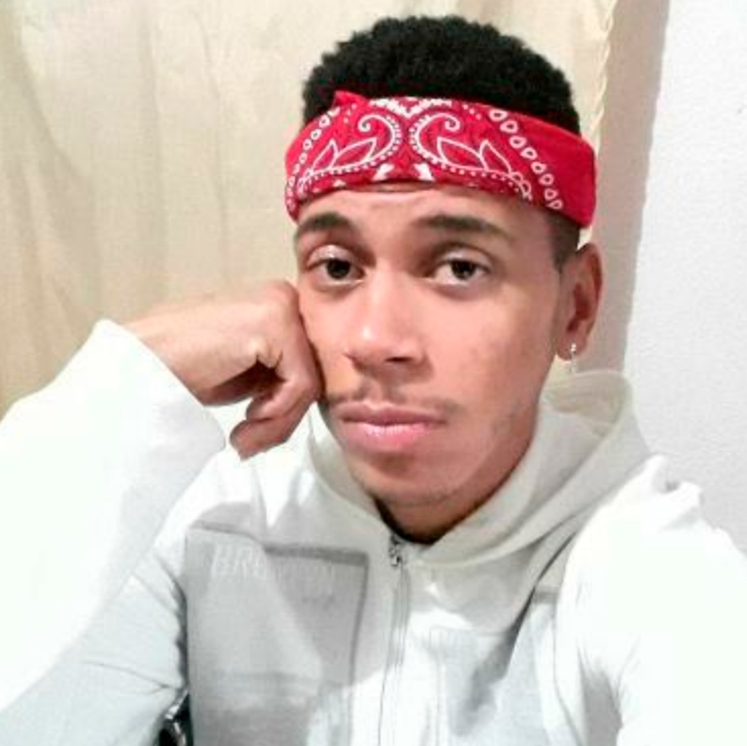 jovem moreno com blusa branca de mangas compridas e capus faixa de lenço vermelho na cabeça