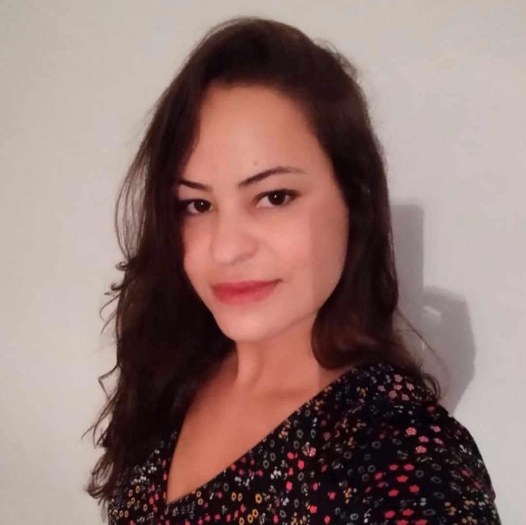 mulher morena clara cabelos castanhos médios longos ondulados vestida com estampa de flores