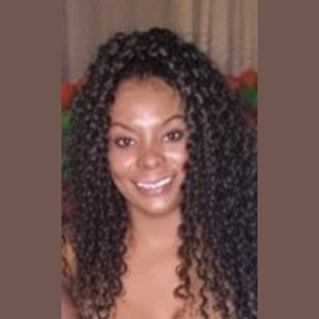 mulher negra cabelos cacheados longos sorrindo