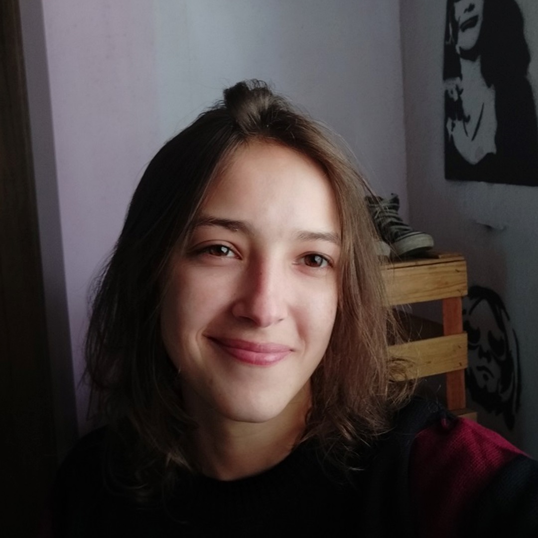 jovem morena clara cabelo castanho claro olhos castanhos claros sorrindo blusa preta e bordô fazendo selfi