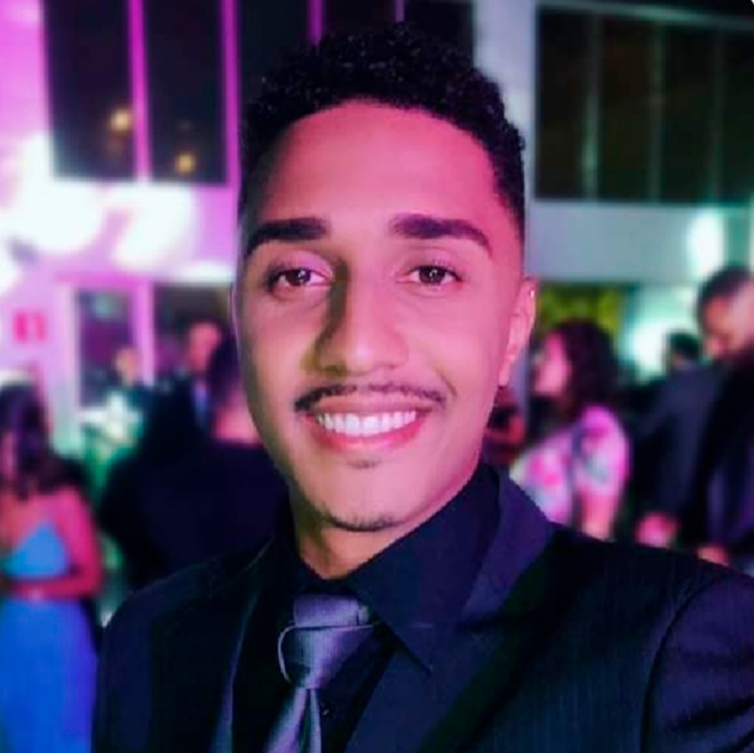 homem moreno claro de bigode barbicha terno e gravata preto
