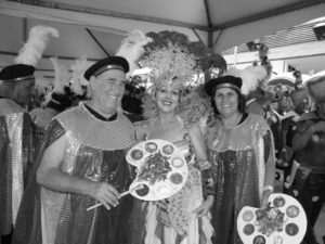 imagem preto e branco com pessoas vestidas de fantasias de carnaval e adereço na cabeça