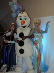 duas mulheres vestidas com vestidos piruca e um boneco de neve tema frozen