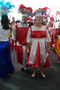casal vestido de fantasias de carnaval vermelho e prata com adereço de cabeça