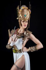 mulher vestida de deusa atenas com adereço de cabeça vestido branco braceletes e unhas acrílicas nail art