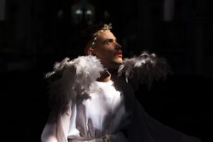 homem vestido de anjo branco olhando para cima